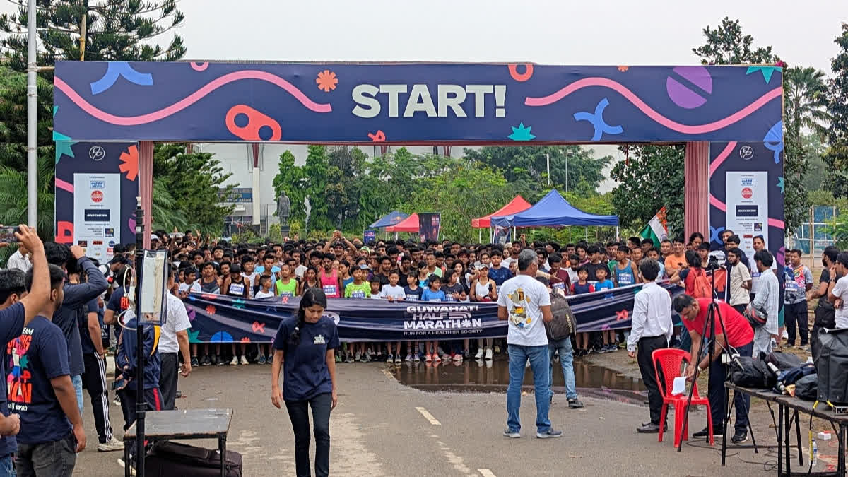 असम में कर्मवीर नबीन चंद्र बर्दोलोई स्टेडियम के पास गुवाहाटी हाफ मैराथन में भाग लेते धावक