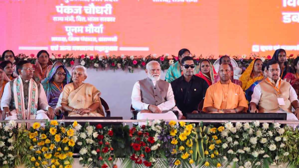 वाराणसी में महिला सम्मेलन के दौरान प्रधानमंत्री नरेंद्र मोदी और अन्य गणमान्य व्यक्ति।