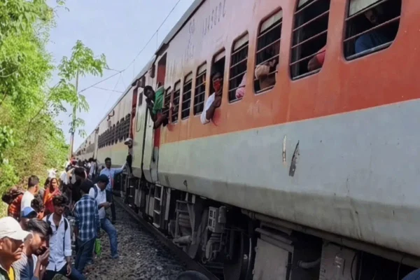 जामताड़ा के पास जयनगर पुरी एक्सप्रेस के जनरल कोच से उठता धुआं और बाहर खड़े यात्री