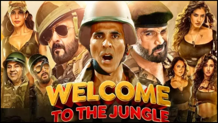 वेलकम टू द जंगल के पोस्टर में अक्षय कुमार नीले रंग के मखमली सूट में जंगल के बीच रेड कार्पेट पर खड़े हैं।