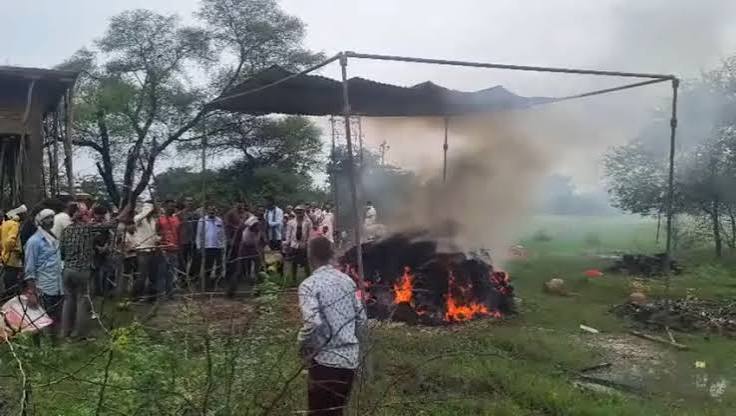 जालौन के गोरा करनपुर में बारिश के बीच टीनशेड के नीचे अंतिम संस्कार करते ग्रामीण